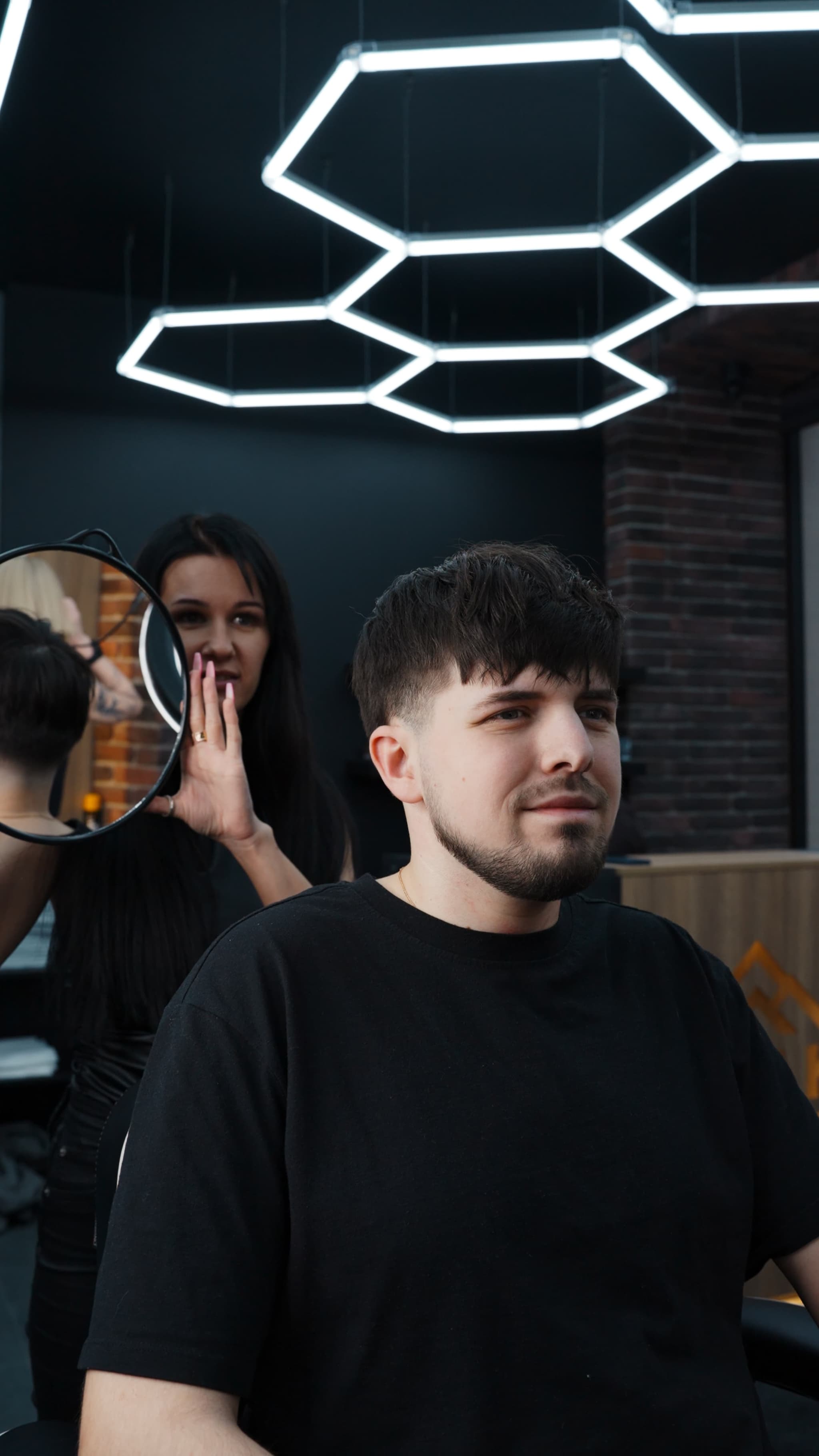 Мужчина со стильной бородой и стрижкой в барбершопе в Риге