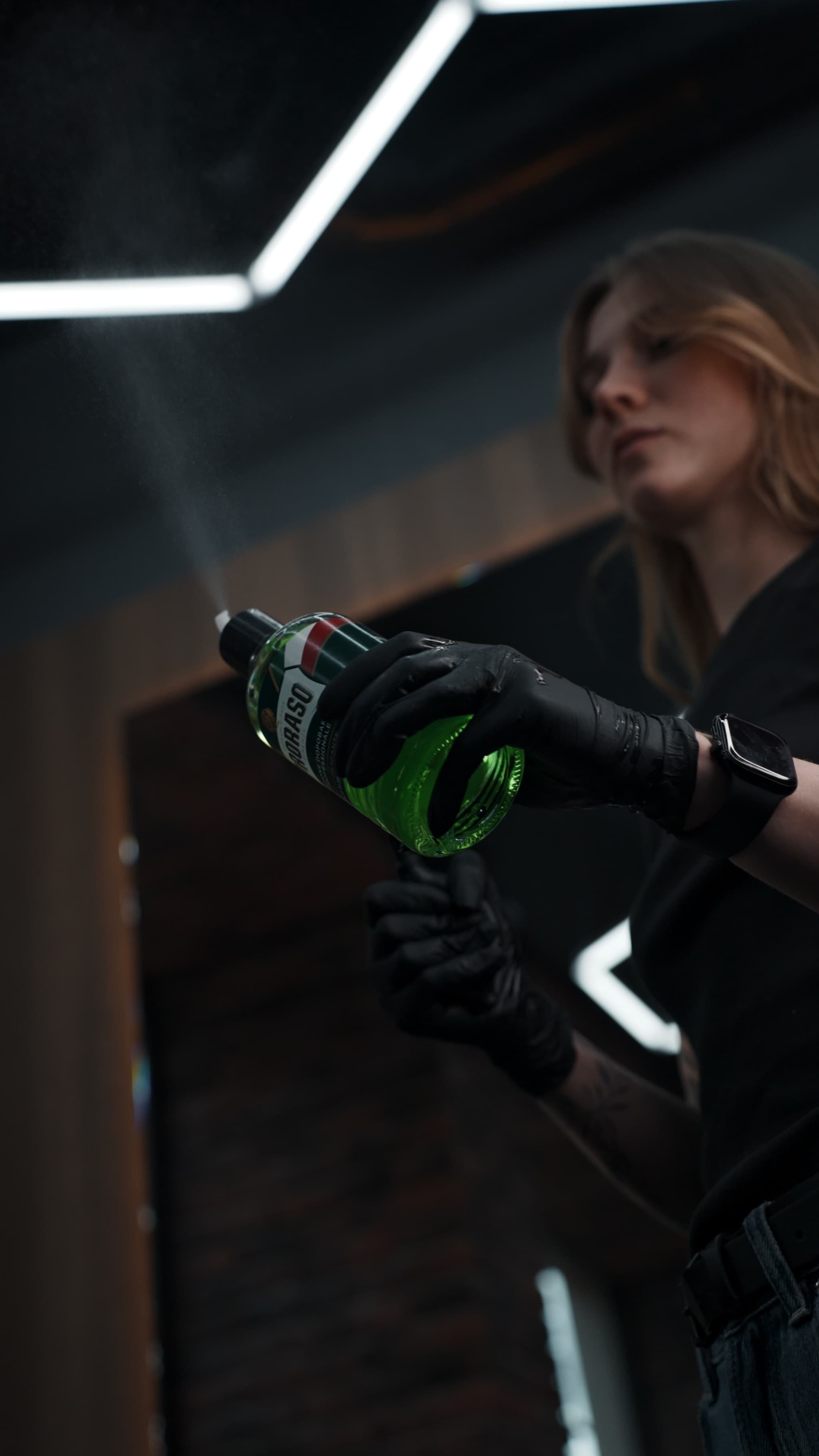 Барбер распыляет профессиональную косметику Proraso в Peak Barbershop в Риге.